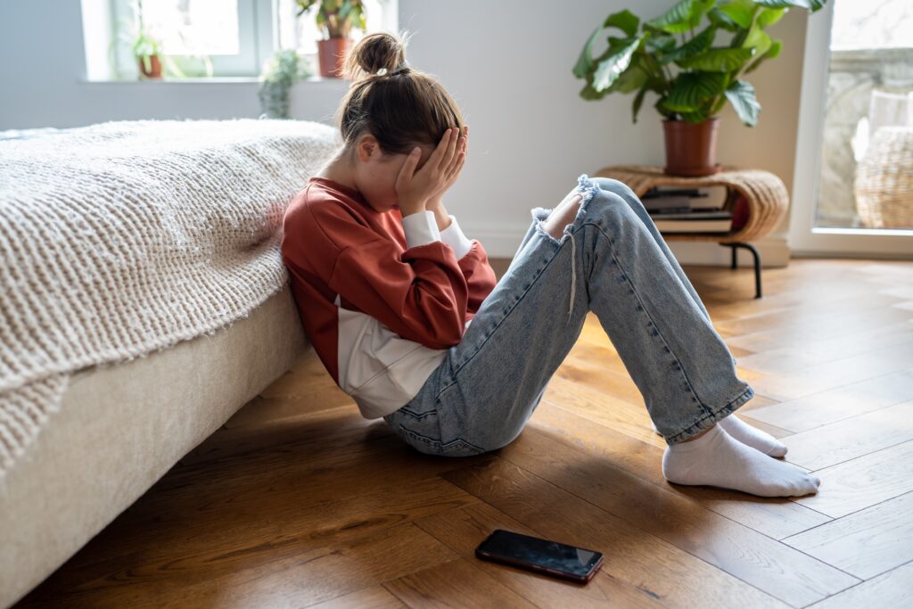 USP: Teen & Child Depression - A teen sitting against bed crying