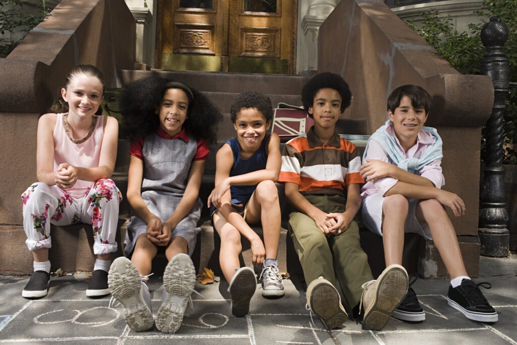 USP: Children & Teens ( A group of happy children sitting on a street curb)